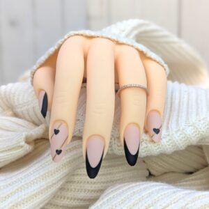 nude almond press on nails with matte black French tips and small black heart accents
